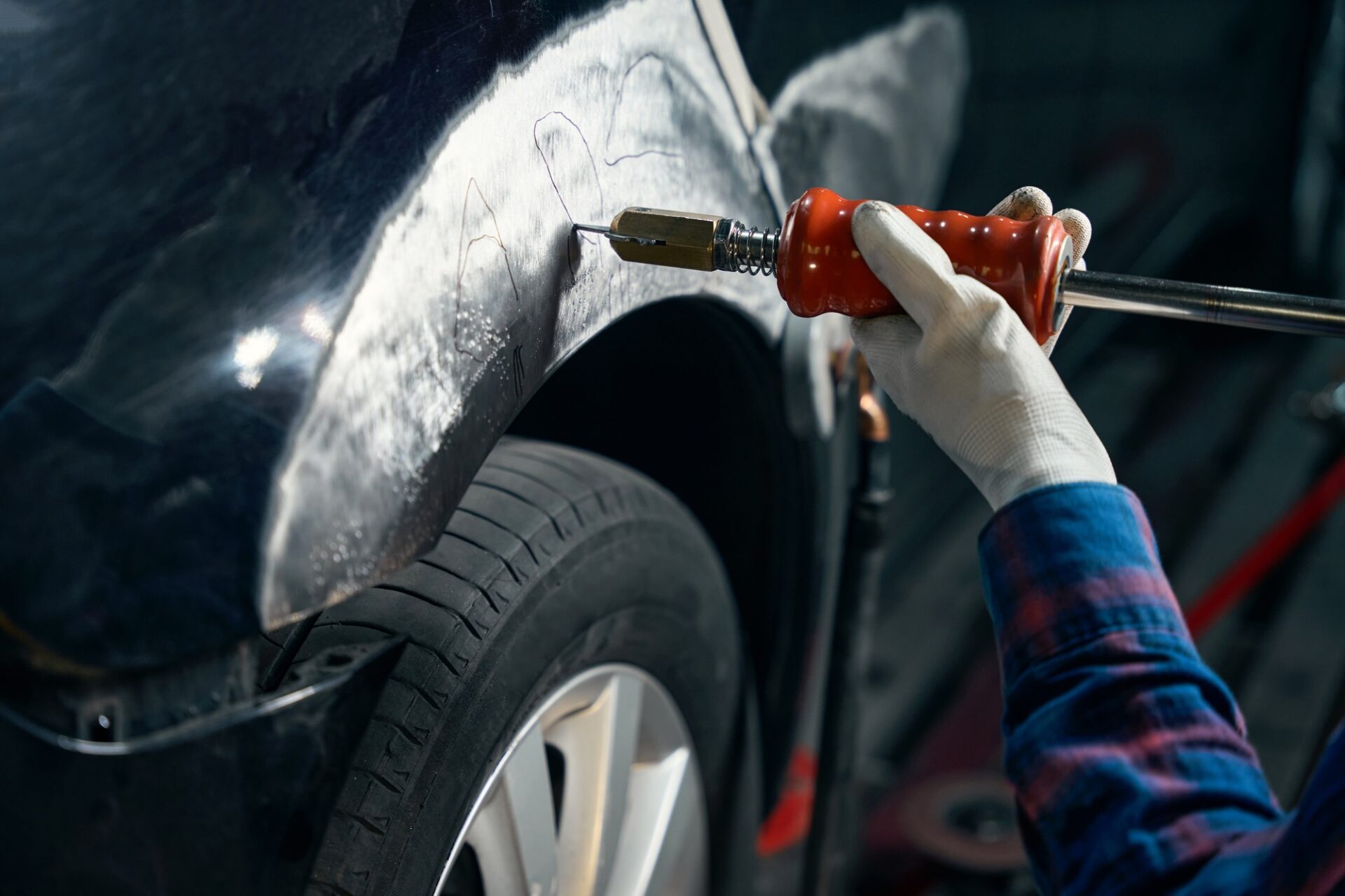 Photo de gros plan d'un homme professionnel en costume de protection debout près de l'automobile, tenant l'instrument et retirer la peinture