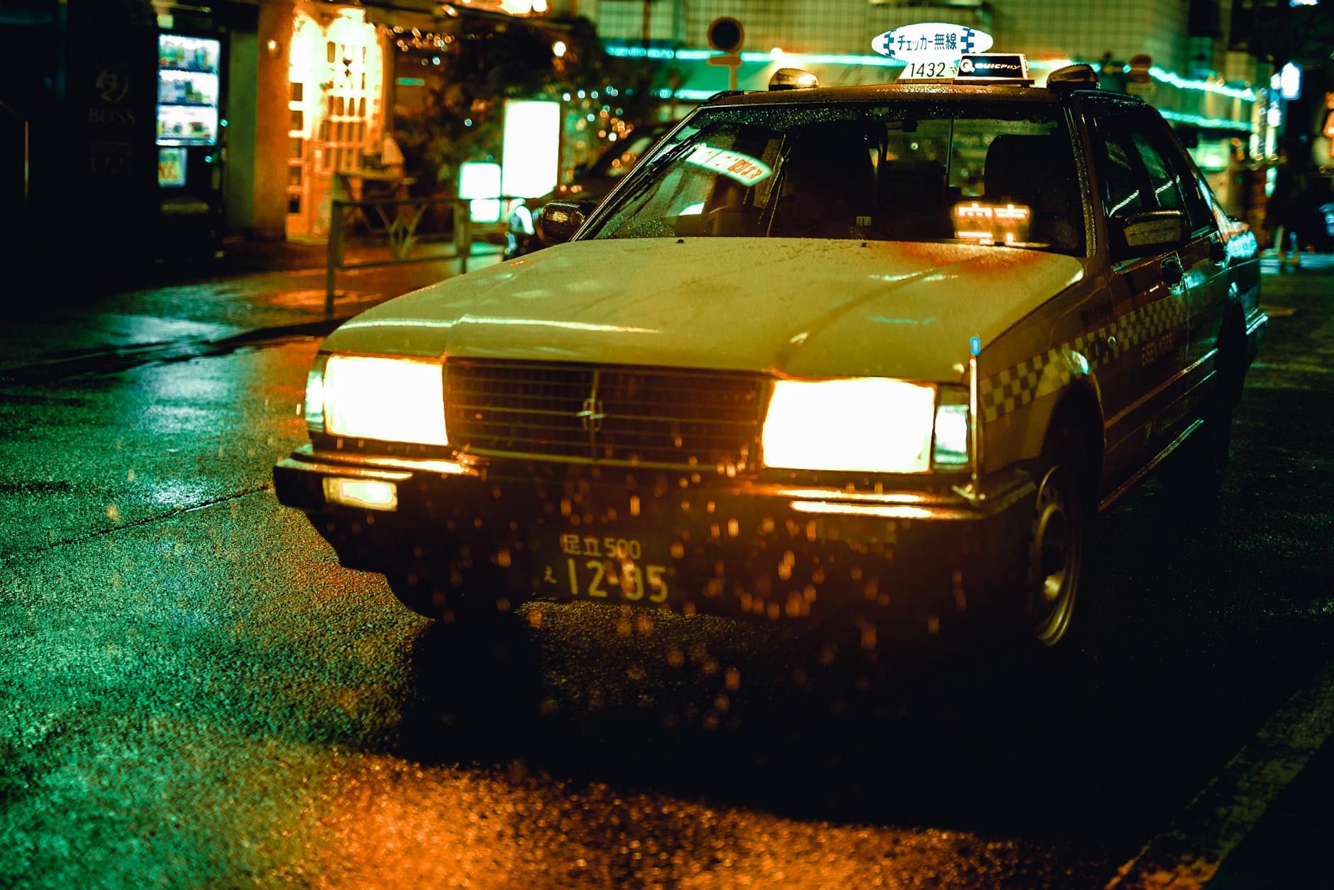Un taxi jaune conduisant dans des rues pluvieuses la nuit à Tokyo, au Japon.