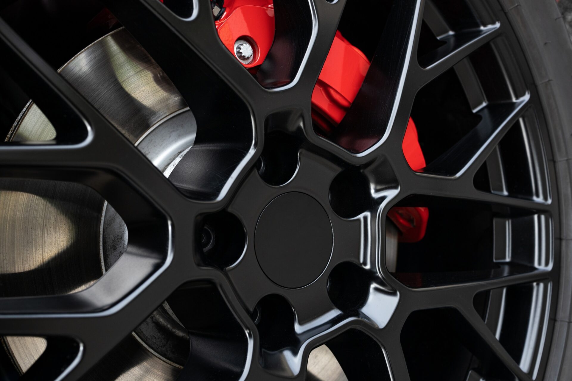 Rim de roues noires et étrier de frein rouge d'une voiture de sport. 