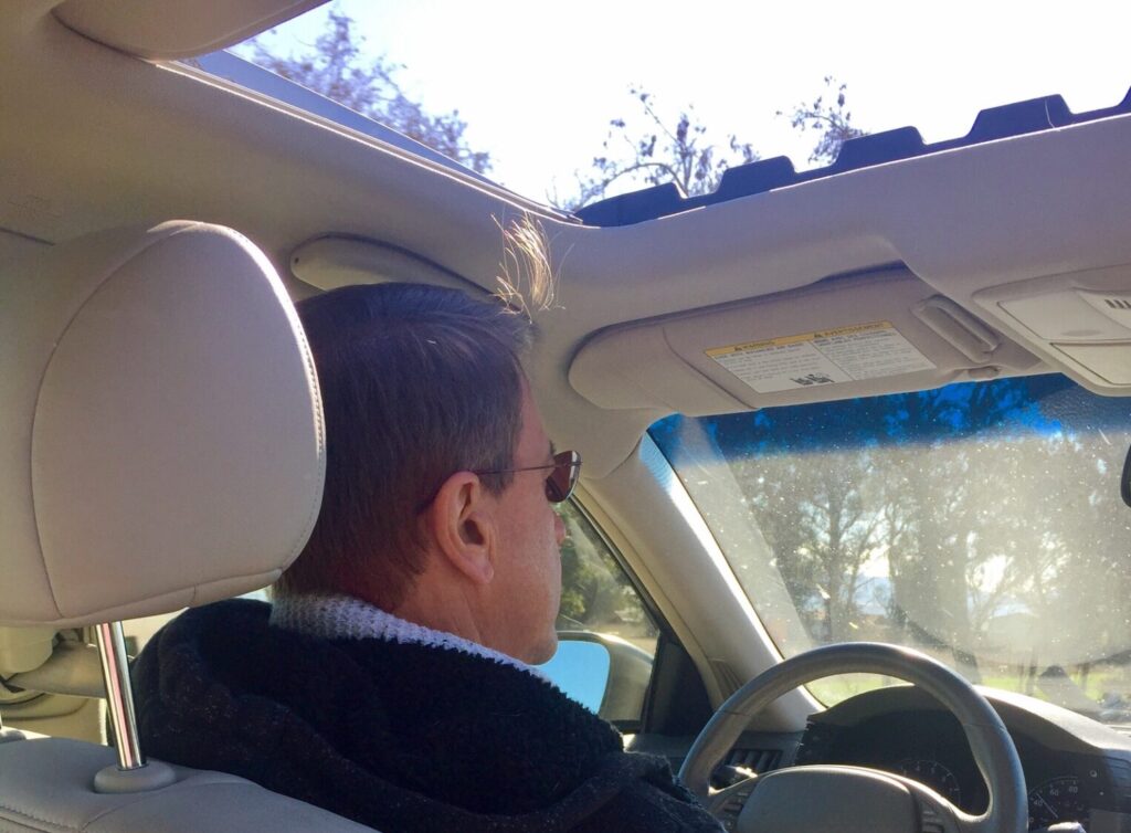 Une vue en côté arrière d'un bel homme d'âge moyen conduisant une voiture ❤️Nation ❤️