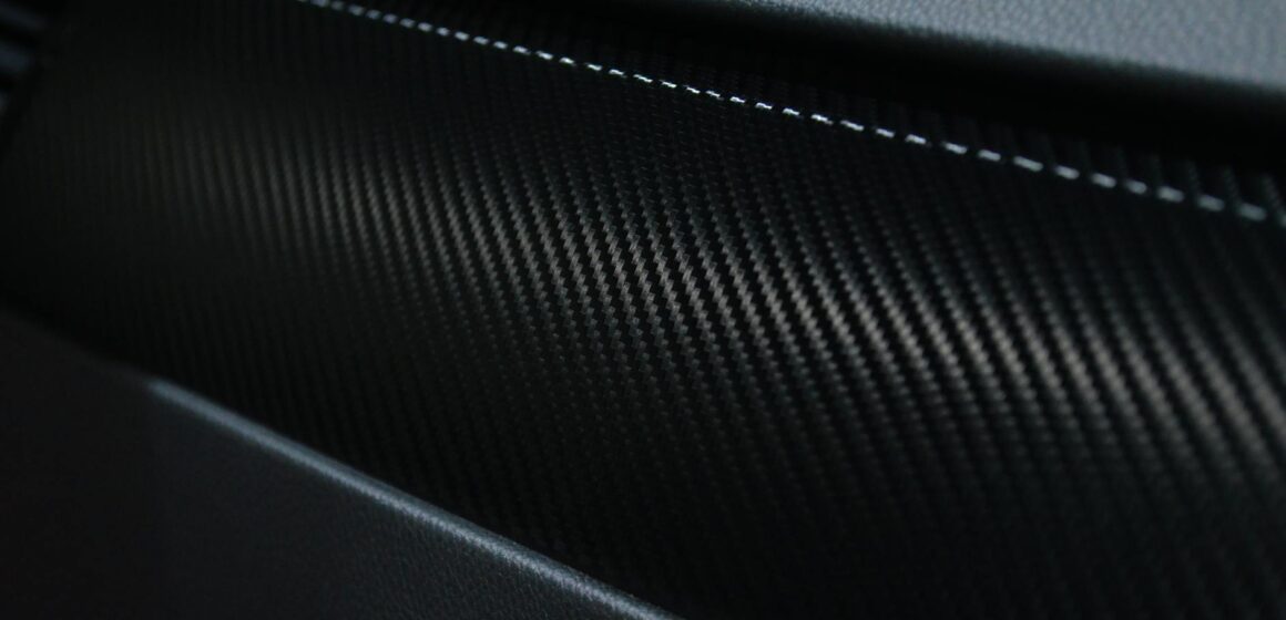 carbon-car Vue détaillée d'une texture en fibre de carbone sur un intérieur de voiture présentant un design moderne.