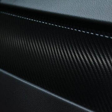 Vue détaillée d'une texture en fibre de carbone sur un intérieur de voiture présentant un design moderne.