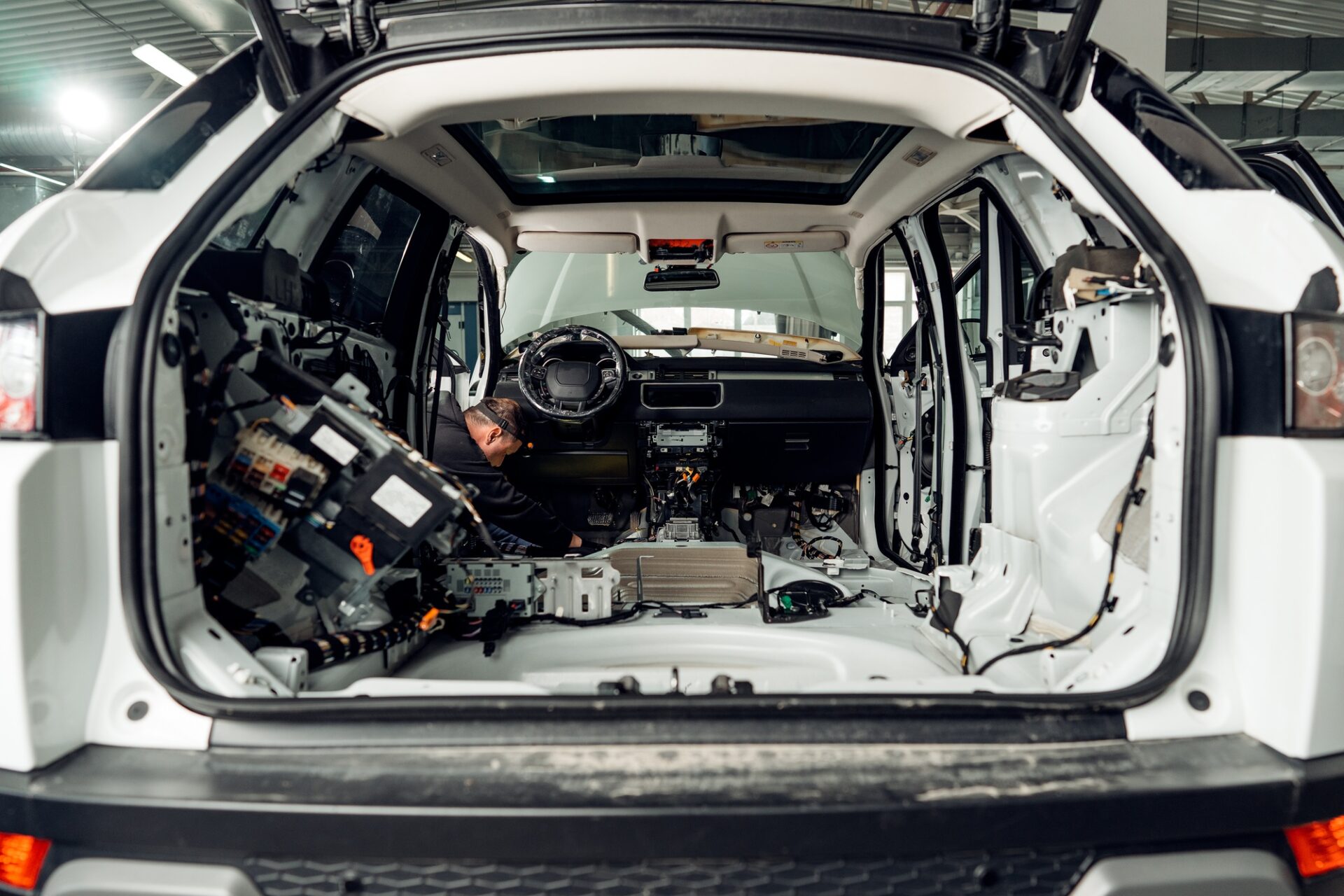 Travailleur des services automobiles installant l'isolation du bruit insonorisation dans le service de voiture