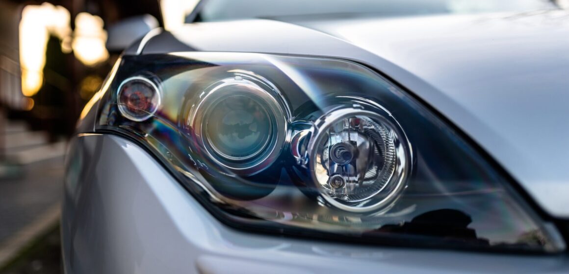 front-headlights Phare avant d'une voiture argentée et moderne avec trois lampes au milieu, une laveuse de phare visible.