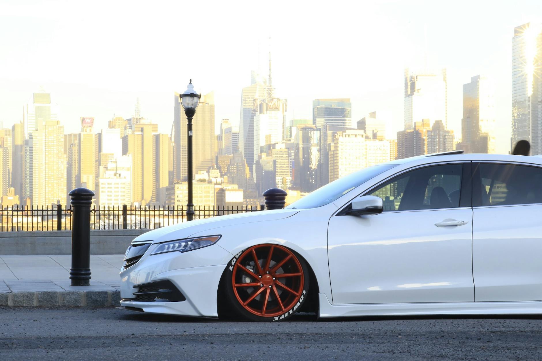 Custom baisée avec une voiture rouge avec des jantes rouges vibrantes contre les toits de New York. 