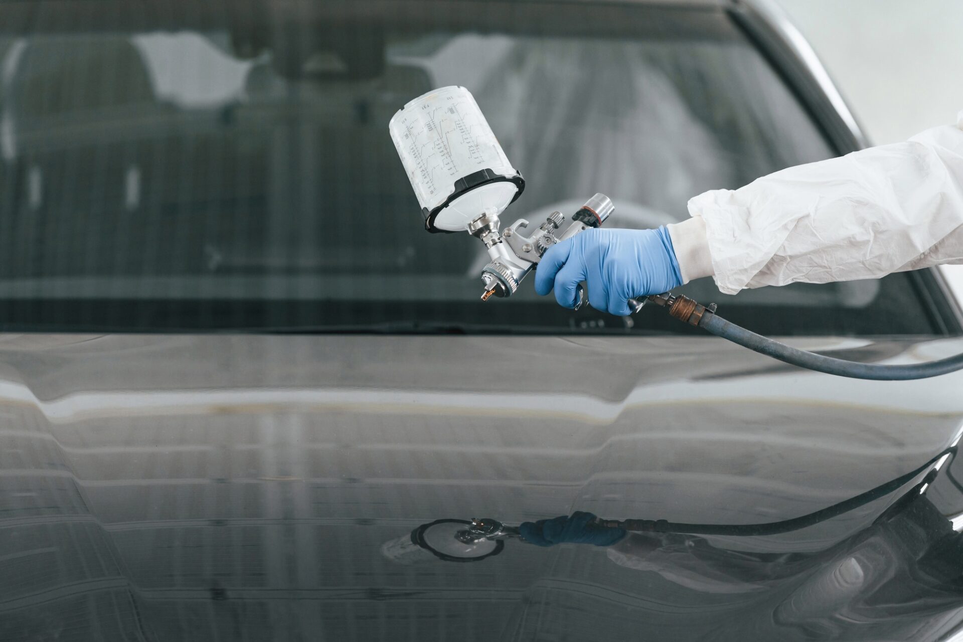 Vue rapprochée de l'homme qui peint une voiture en utilisant Spray Guy.