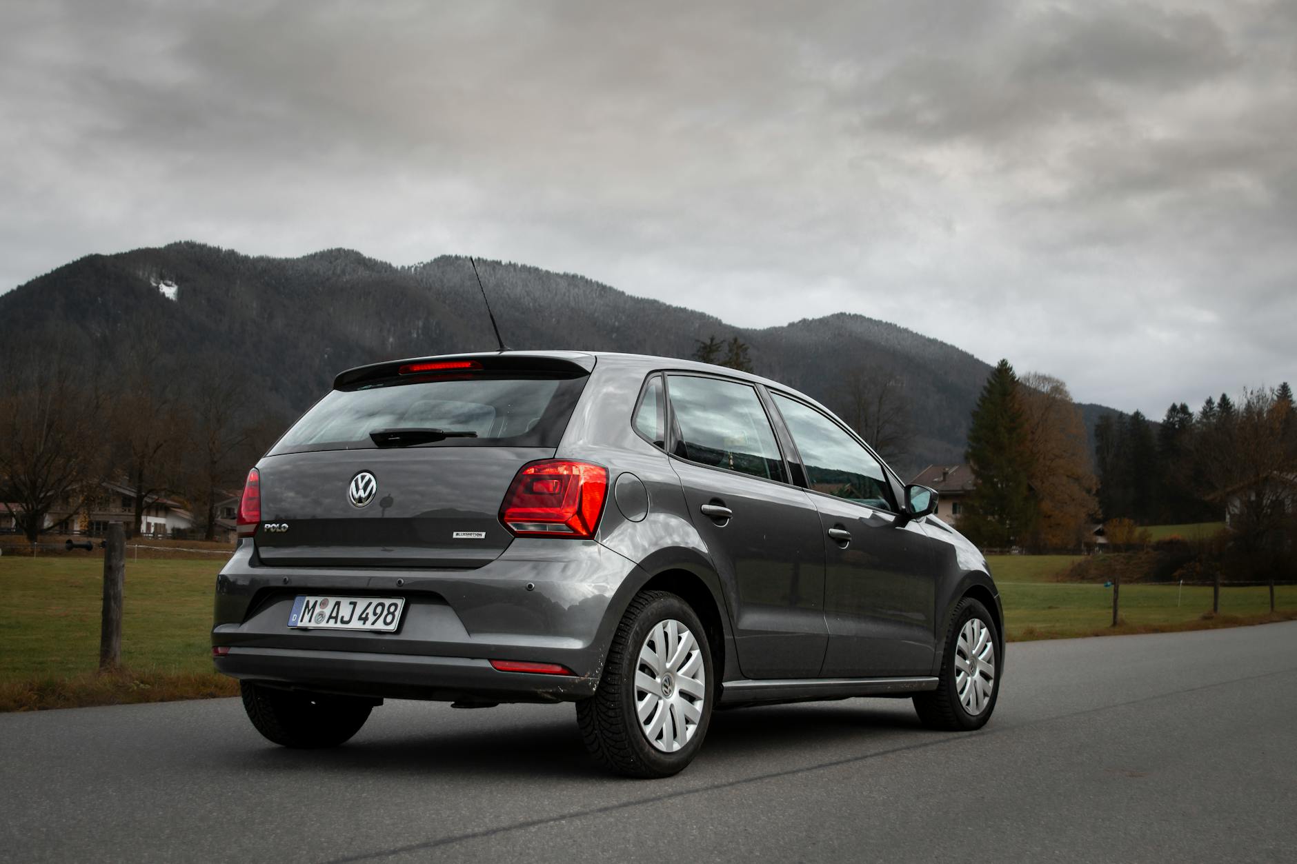 La voiture Volkswagen s'est garée sur une route panoramique à Tegernsee, en Allemagne, avec des montagnes en arrière-plan.
