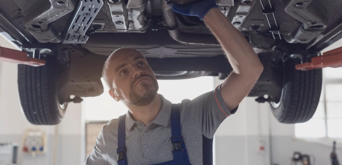 Coolant-leak Mécanicien professionnel travaillant sous une voiture dans un atelier de réparation, concept de maintenance et de réparation de la voiture