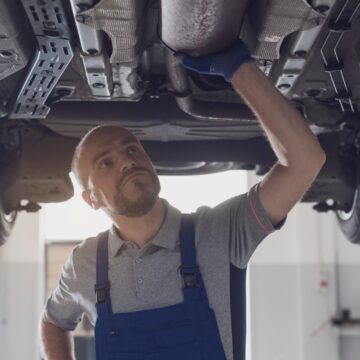 Coolant-leak Mécanicien professionnel travaillant sous une voiture dans un atelier de réparation, concept de maintenance et de réparation de la voiture