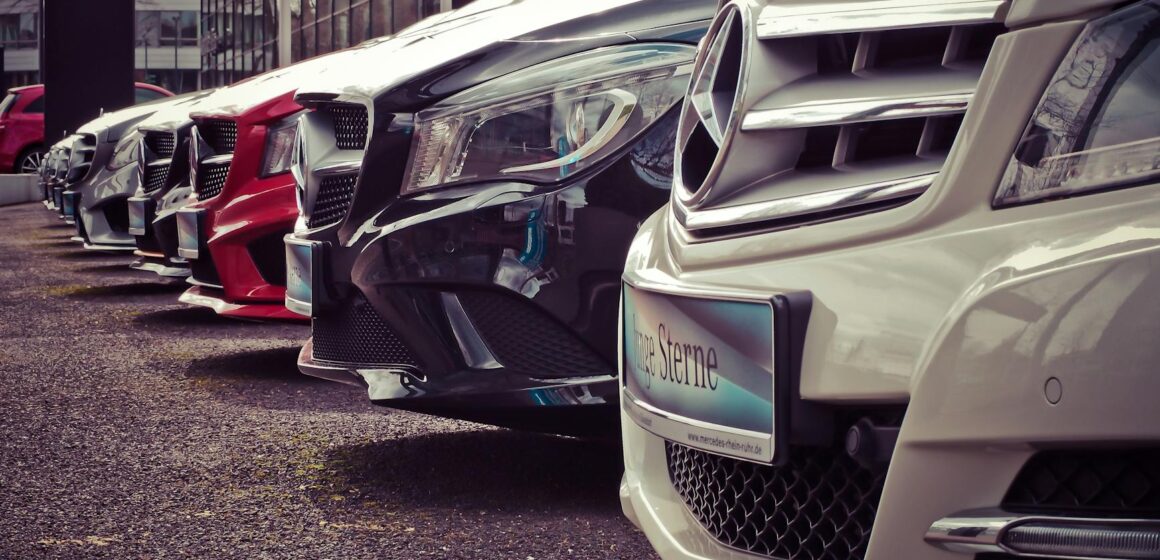 buy-car Des voitures de luxe alignées chez un concessionnaire en plein air, présentant des dessins élégants.
