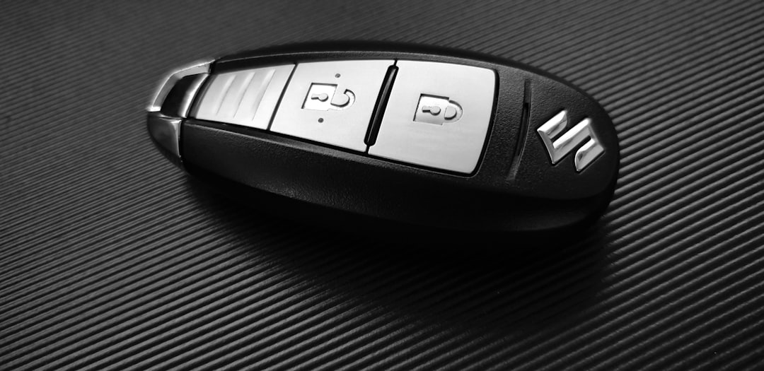Porte-clés de voiture Suzuki gris et noir sur surface noire