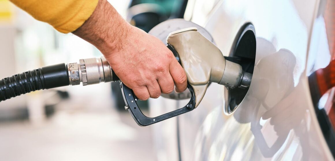 carburant-voiture Gros plan d'une personne faisant le plein d'une voiture avec une buse à gaz dans une station.