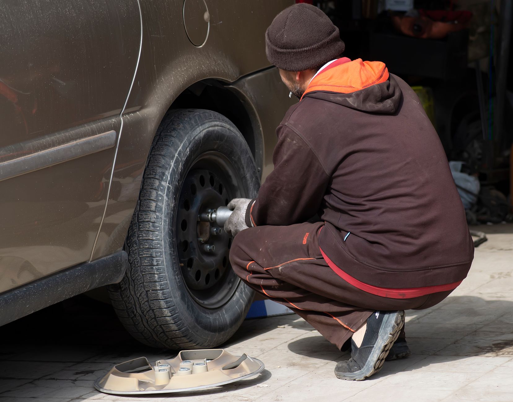 Un mécanicien travaillant sur un pneu de voiture et le changeant dans un atelier de réparation automobile.