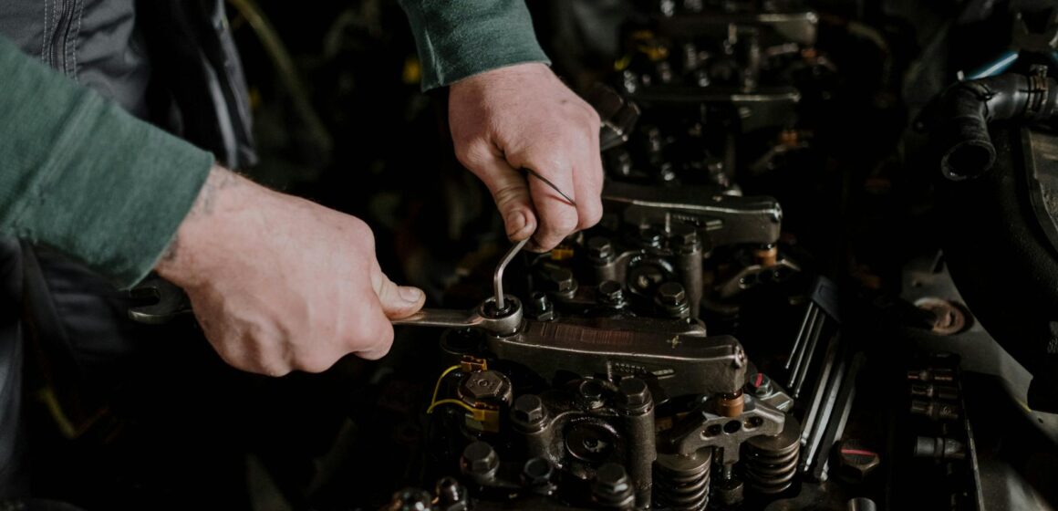 moteur-diesel Gros plan d'un mécanicien utilisant des outils manuels pour réparer un moteur, faisant preuve de précision et d'habileté.