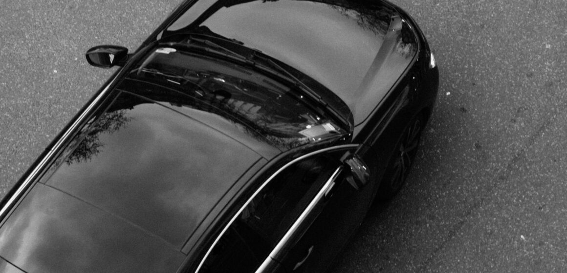 toiture-de-vehicule Image monochrome d'une voiture noire vue d'en haut, mettant en valeur son design élégant et sa surface réfléchissante.