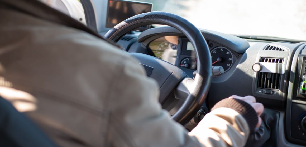 conducteur Homme âgé conduisant une camionnette pendant une journée ensoleillée au Portugal, mettant en valeur la sécurité et les voyages de loisirs.