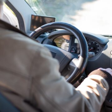 conducteur Homme âgé conduisant une camionnette pendant une journée ensoleillée au Portugal, mettant en valeur la sécurité et les voyages de loisirs.