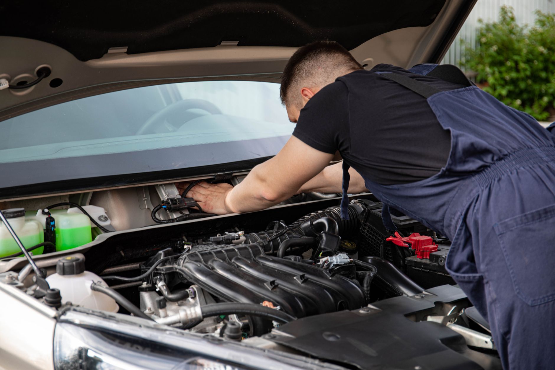 Un mécanicien automobile effectue l'entretien du moteur d'une voiture.